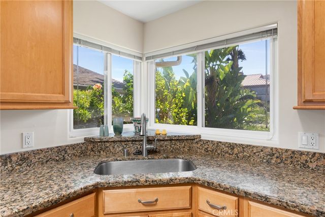 a kitchen with granite countertop sink and window
