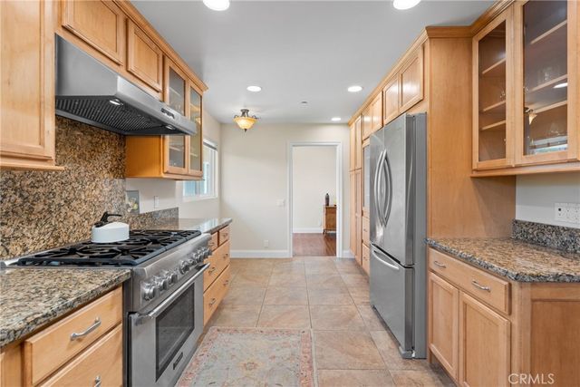a kitchen with stainless steel appliances granite countertop a stove a sink and a refrigerator