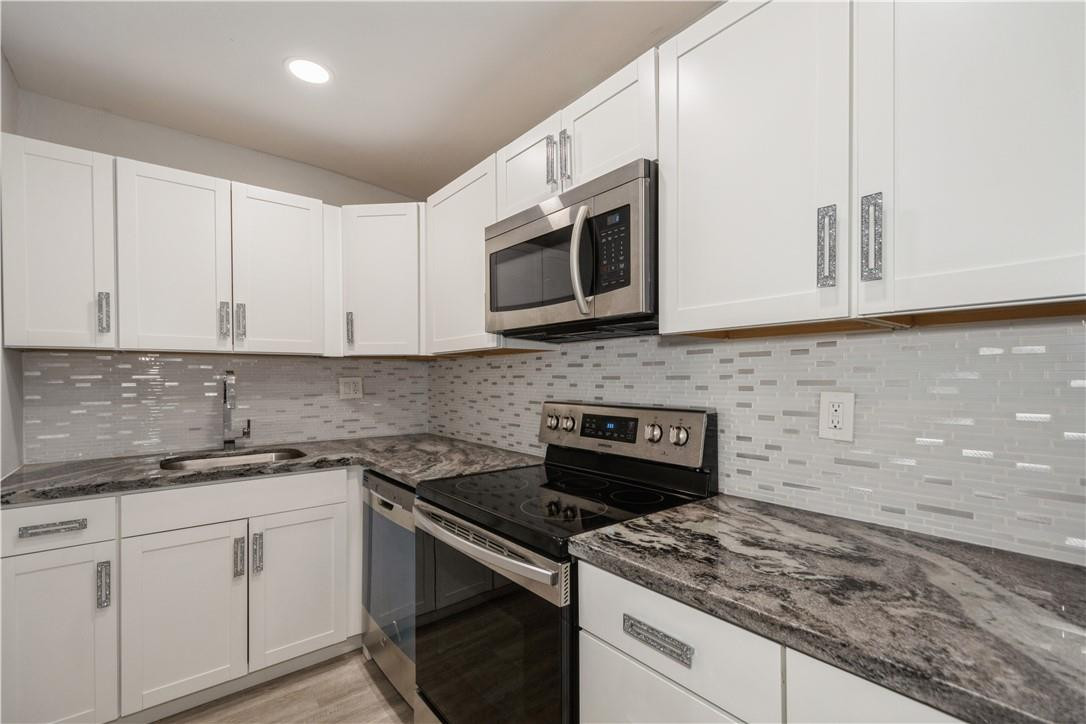 200 South Birch Road, Unit 612 Fort Lauderdale, FL 33316 - Photo 13 of 32 a kitchen with stainless steel appliances granite countertop white cabinets granite counter tops and a hard wood floors