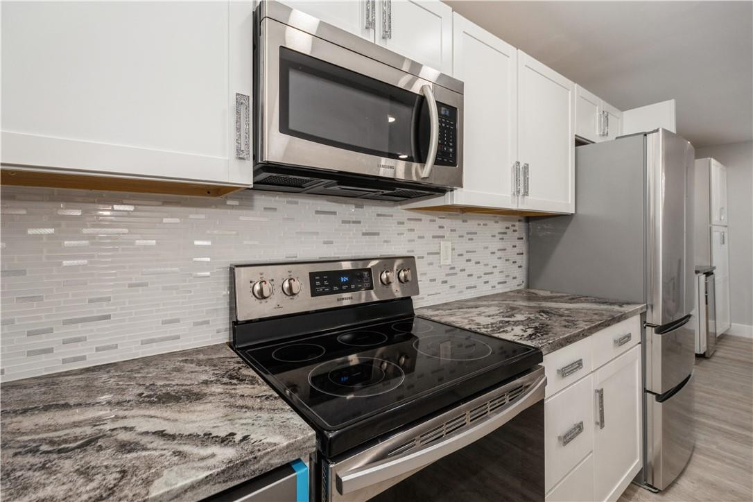 200 South Birch Road, Unit 612 Fort Lauderdale, FL 33316 - Photo 14 of 32 a kitchen with stainless steel appliances granite countertop a stove microwave and refrigerator
