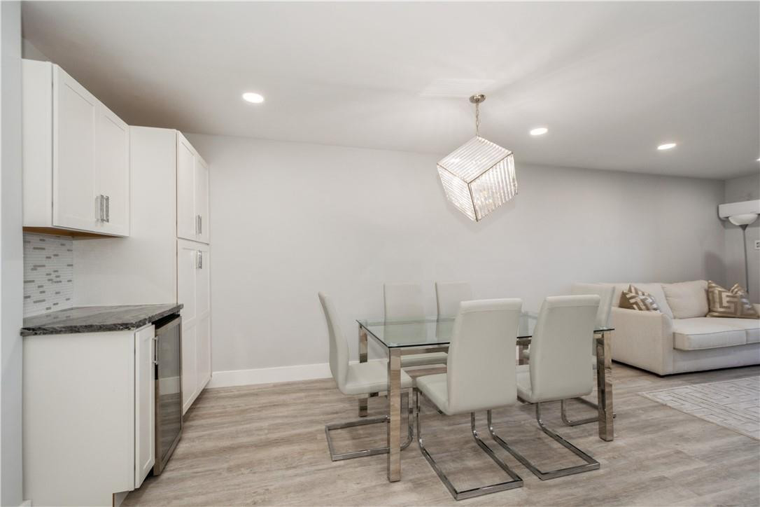 200 South Birch Road, Unit 612 Fort Lauderdale, FL 33316 - Photo 17 of 32 a dining room with wooden floor a chandelier a wooden table and chairs