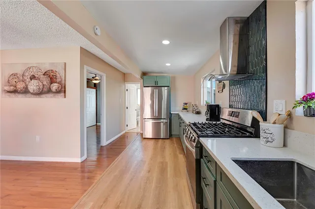 a kitchen with stainless steel appliances granite countertop a sink stove and refrigerator