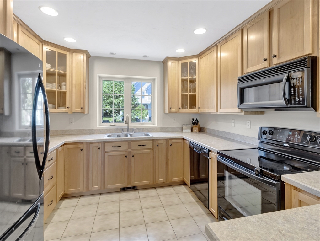 13 Shawmut Avenue, Unit 13 Mansfield, MA 02048 - Photo 9 of 34 a kitchen with stainless steel appliances granite countertop a stove a sink and a microwave