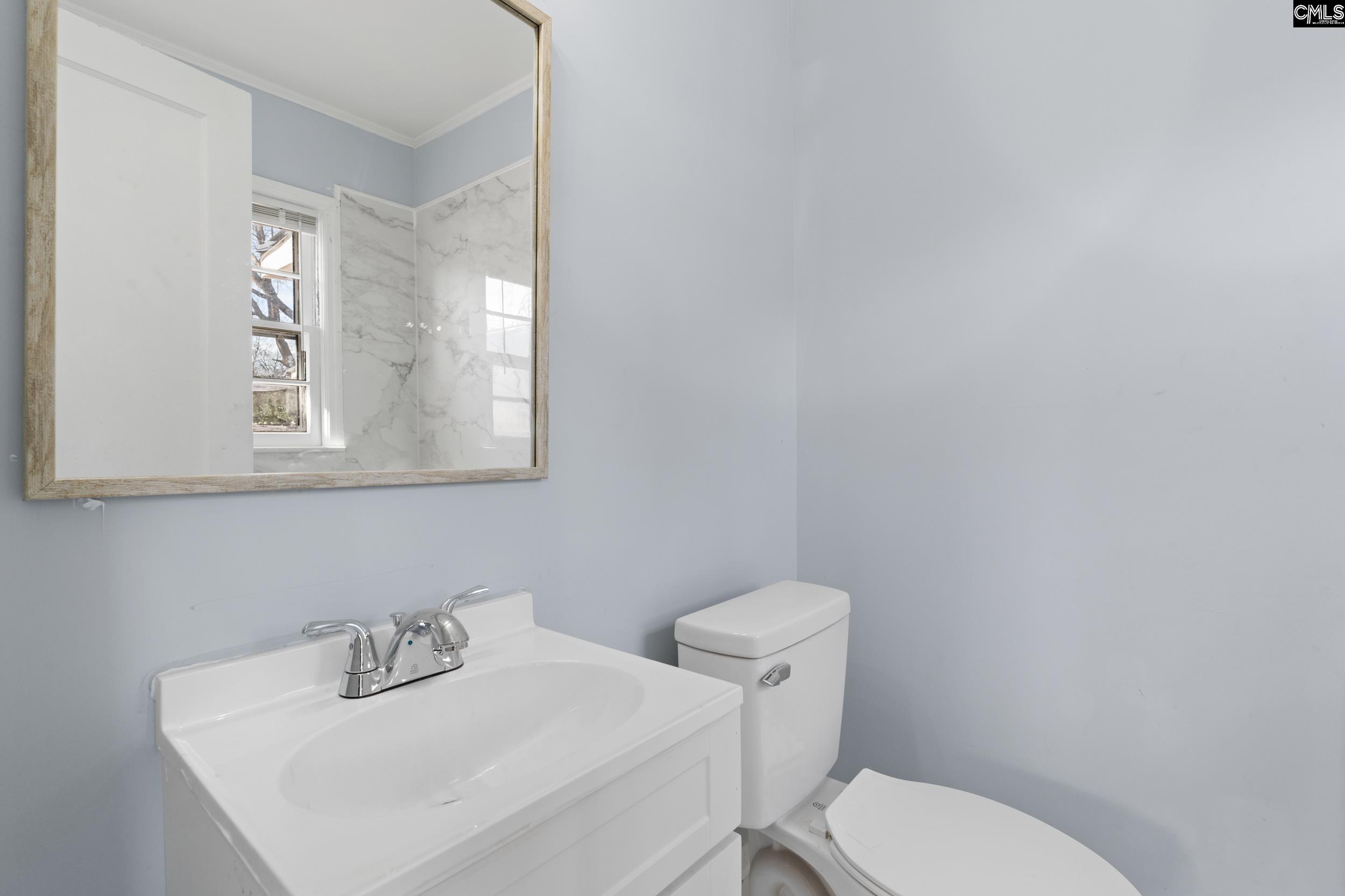 409 Wilkes Road Columbia, SC 29203 - Photo 23 of 34 a bathroom with a toilet sink and mirror