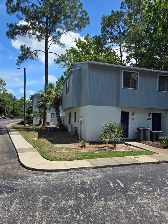 a view of a house with backyard and trees