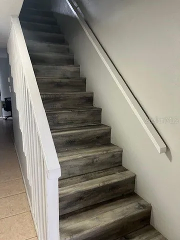 a view of a hallway with wooden floor and stairs