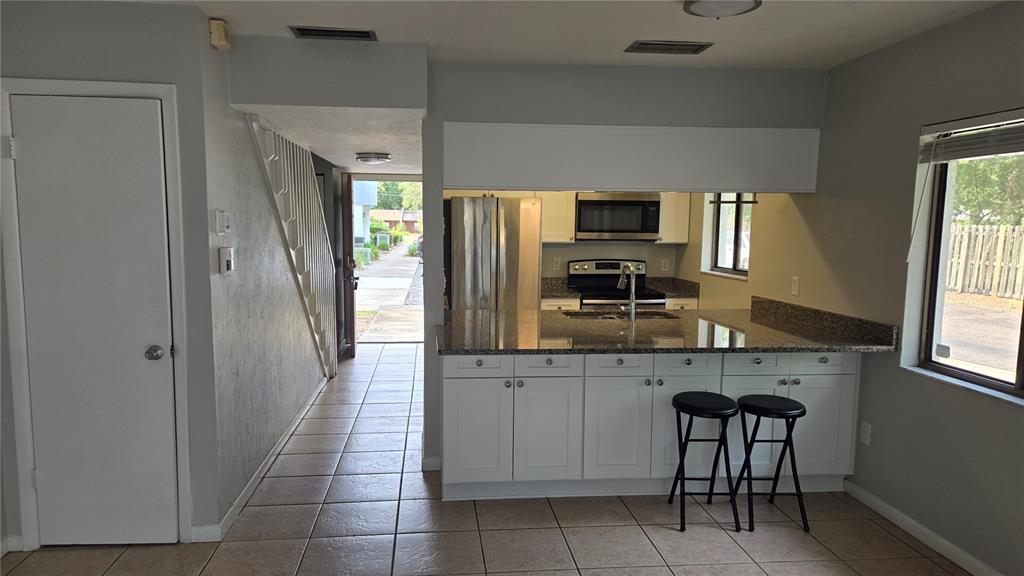 3600 Southwest 19th Avenue, Unit 41D Gainesville, FL 32607 - Photo 2 of 23 a kitchen with a sink a microwave and wooden cabinets