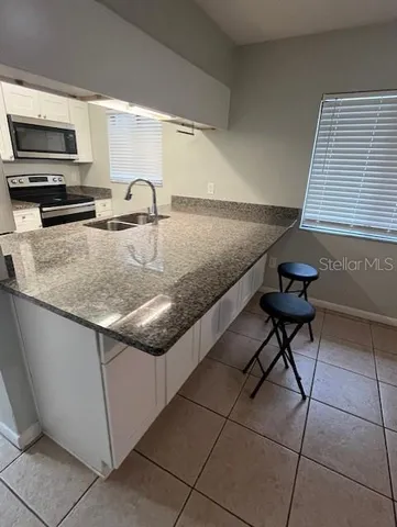 a kitchen with stainless steel appliances granite countertop a sink and a stove
