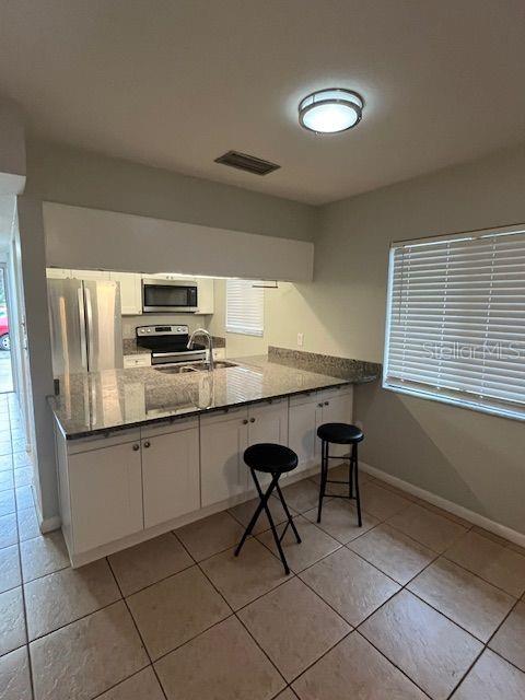 3600 Southwest 19th Avenue, Unit 41D Gainesville, FL 32607 - Photo 8 of 23 a kitchen with stainless steel appliances granite countertop a stove a sink and a microwave