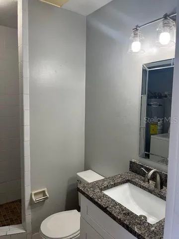 a bathroom with a granite countertop sink and a mirror