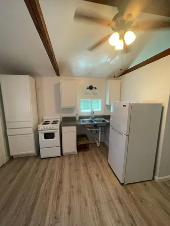 a kitchen with cabinets wooden floor and stainless steel appliances