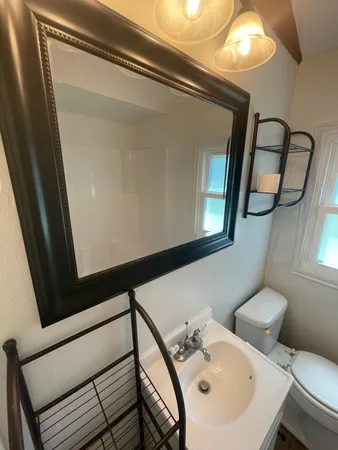 a bathroom with a sink mirror and toilet
