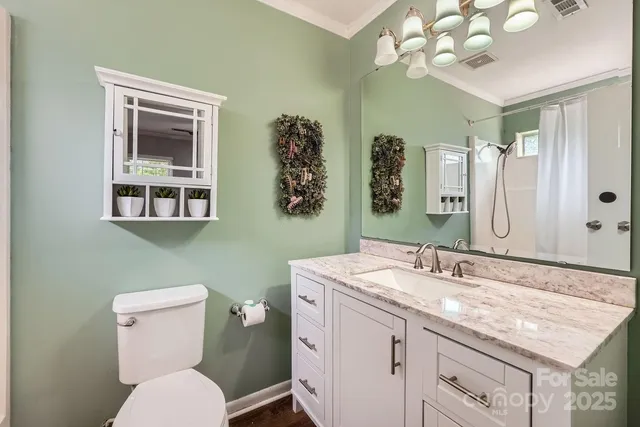 a bathroom with a granite countertop toilet sink and mirror