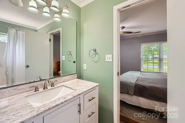 a en suite bathroom with a granite countertop sink and a mirror