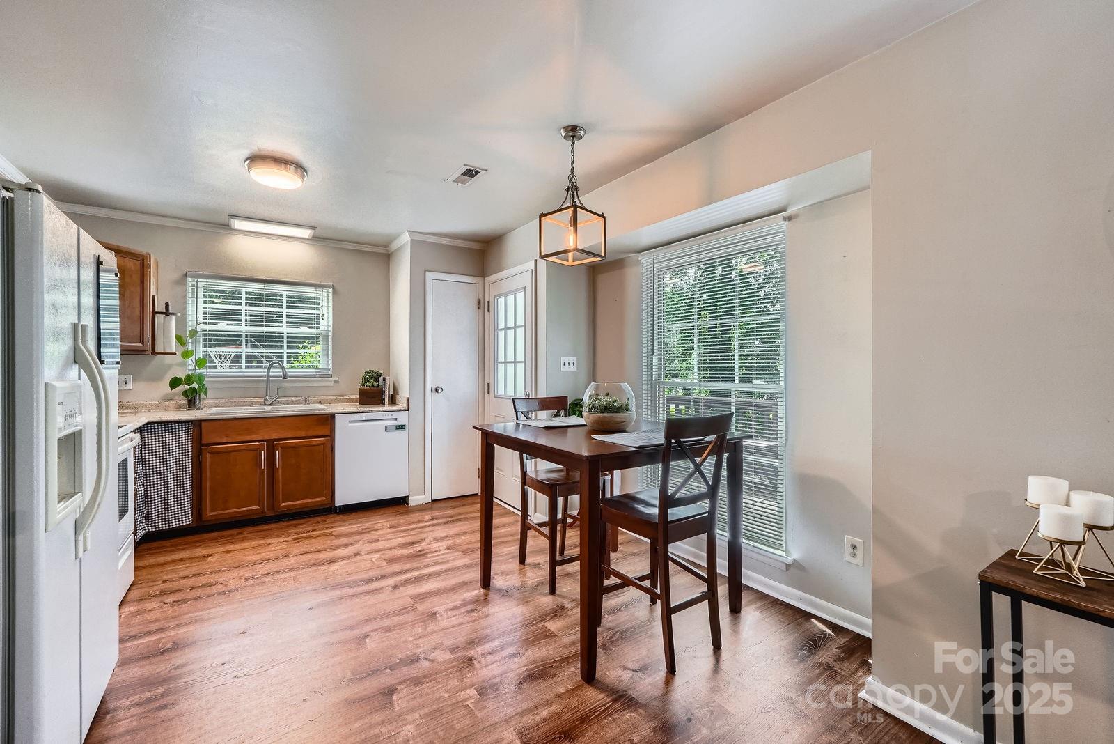 2009 Pinevalley Road Rock Hill, SC 29732 - Photo 22 of 27 a kitchen with stainless steel appliances granite countertop a stove a sink dishwasher a dining table and chairs with wooden floor