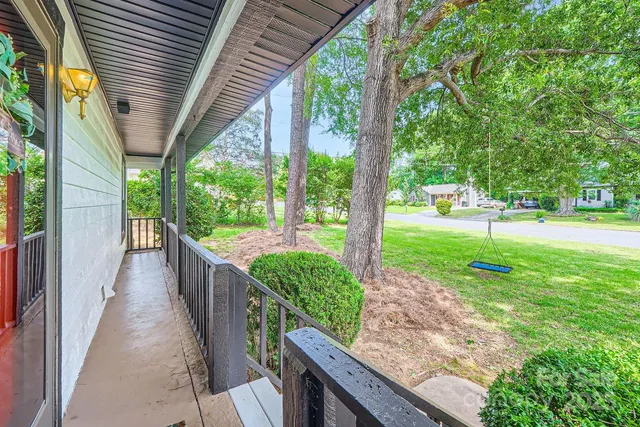 a view of a porch with a big yard potted plants and large tree