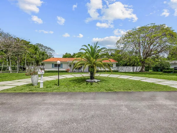 a view of backyard with swimming pool and green space