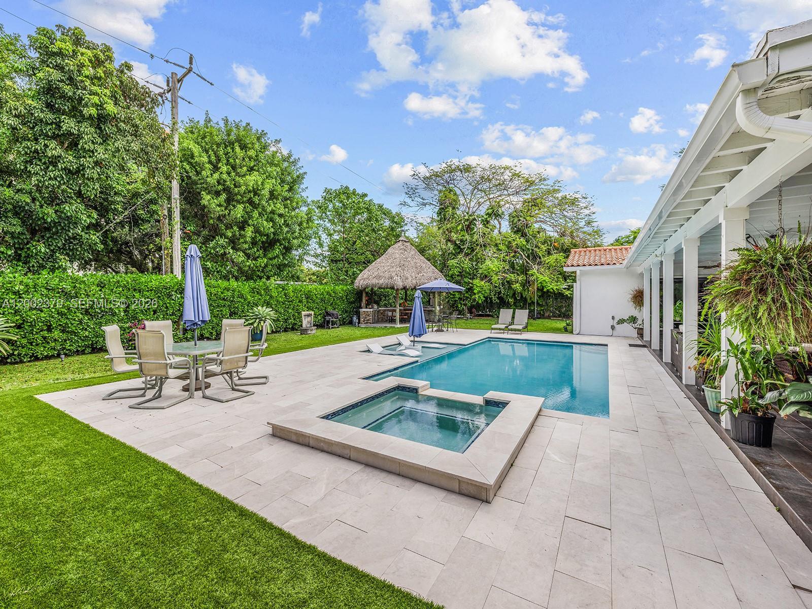7495 Southwest 73rd Terrace Miami, FL 33143 - Photo 21 of 33 a view of a patio with a table and chairs under an umbrella