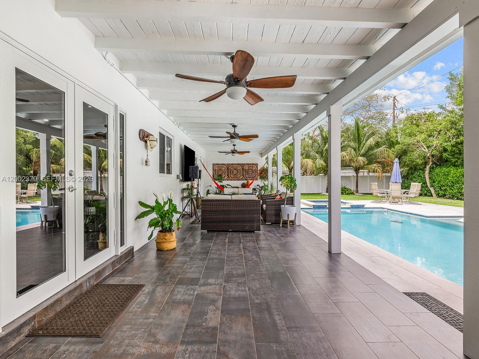 7495 Southwest 73rd Terrace Miami, FL 33143 - Photo 23 of 33 a living room with patio furniture and a floor to ceiling window