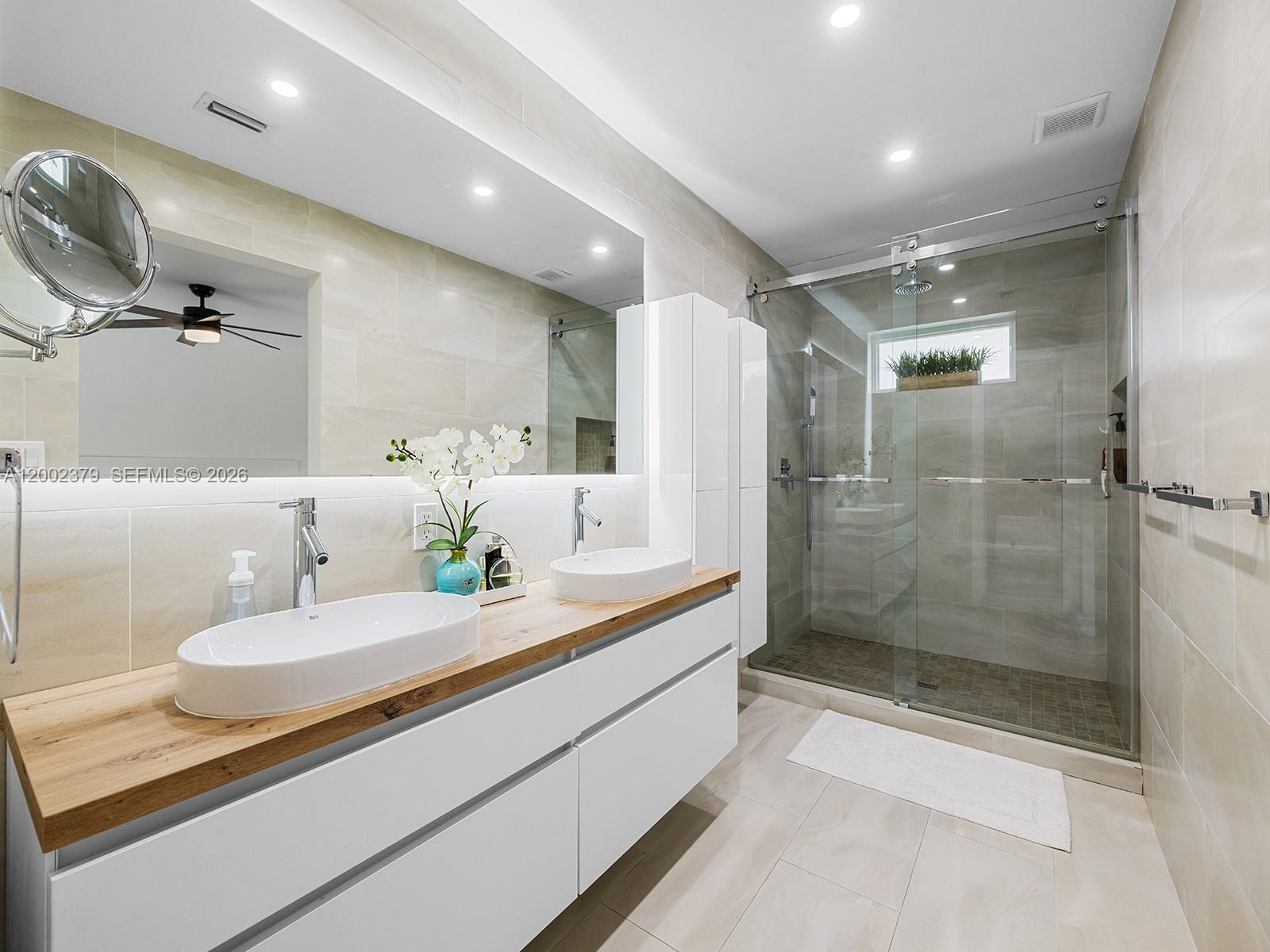 7495 Southwest 73rd Terrace Miami, FL 33143 - Photo 27 of 33 a bathroom with a double vanity sink mirror and shower