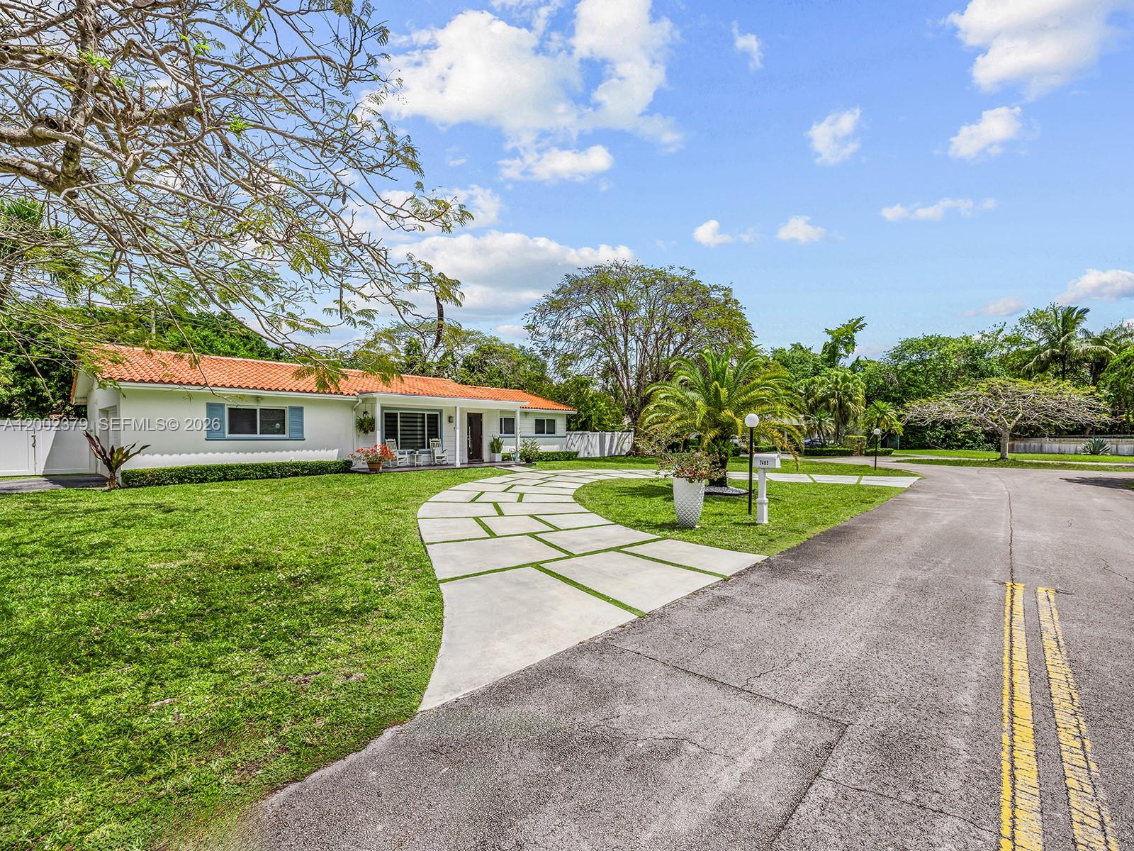 7495 Southwest 73rd Terrace Miami, FL 33143 - Photo 4 of 33 a front view of a house with a big yard and potted plants