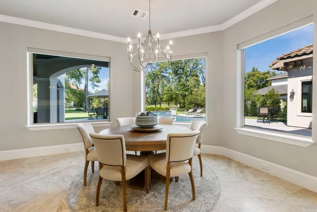 a dining room with furniture a chandelier and window