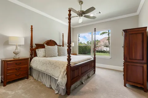 a spacious bedroom with a bed chandelier and a window