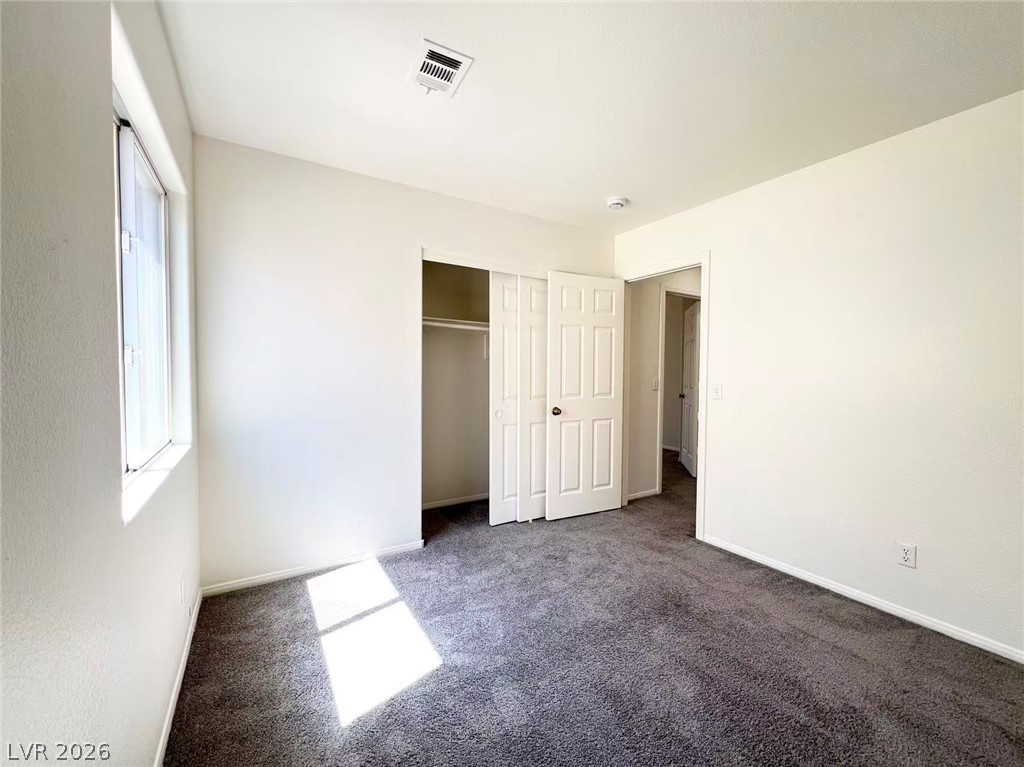8284 West Rochelle Avenue Las Vegas, NV 89147 - Photo 19 of 29 A well-lit bedroom features plush carpeting and a convenient sliding closet.