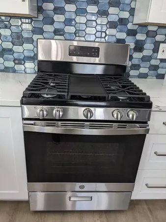 a stove top oven sitting inside of a kitchen