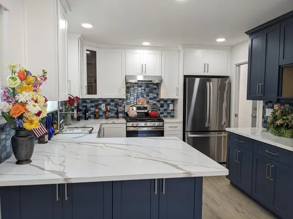 a kitchen with stainless steel appliances kitchen island granite countertop a refrigerator and a sink