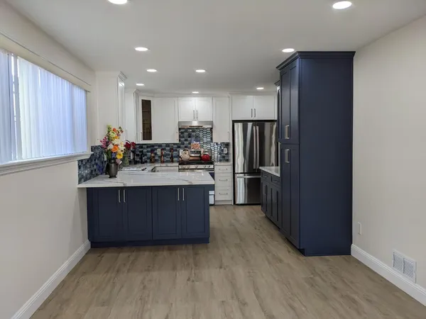 a kitchen with stainless steel appliances a refrigerator and a cabinets