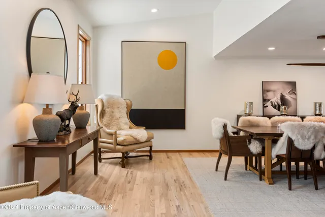 a dining room with furniture a rug and a painting