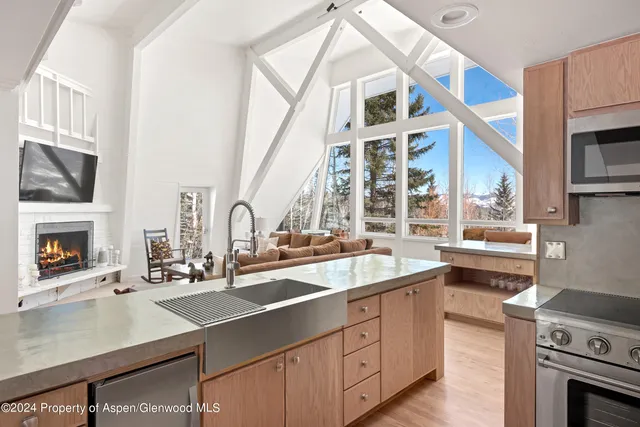 a kitchen with stainless steel appliances granite countertop a sink window and cabinets