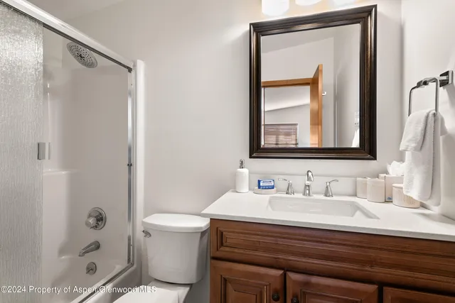 a bedroom with a bed and large windows