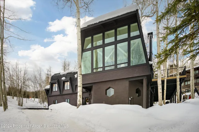 a front view of a house with a yard covered in snow