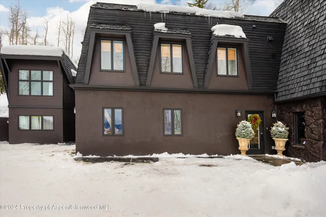 a front view of a house with a yard covered in snow