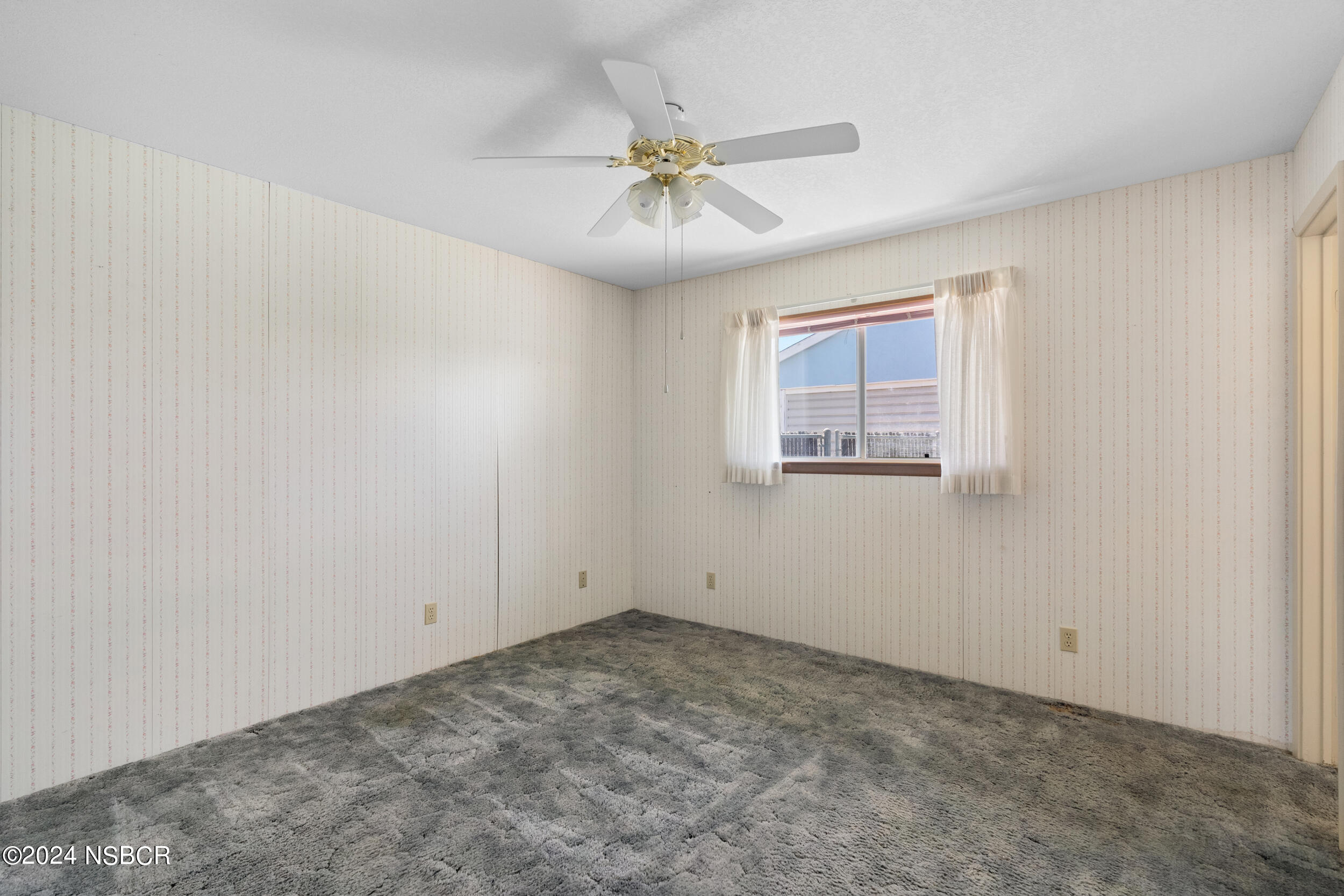 4188 Constellation Road Lompoc, CA 93436 - Photo 18 of 37 an empty room with a ceiling fan and windows