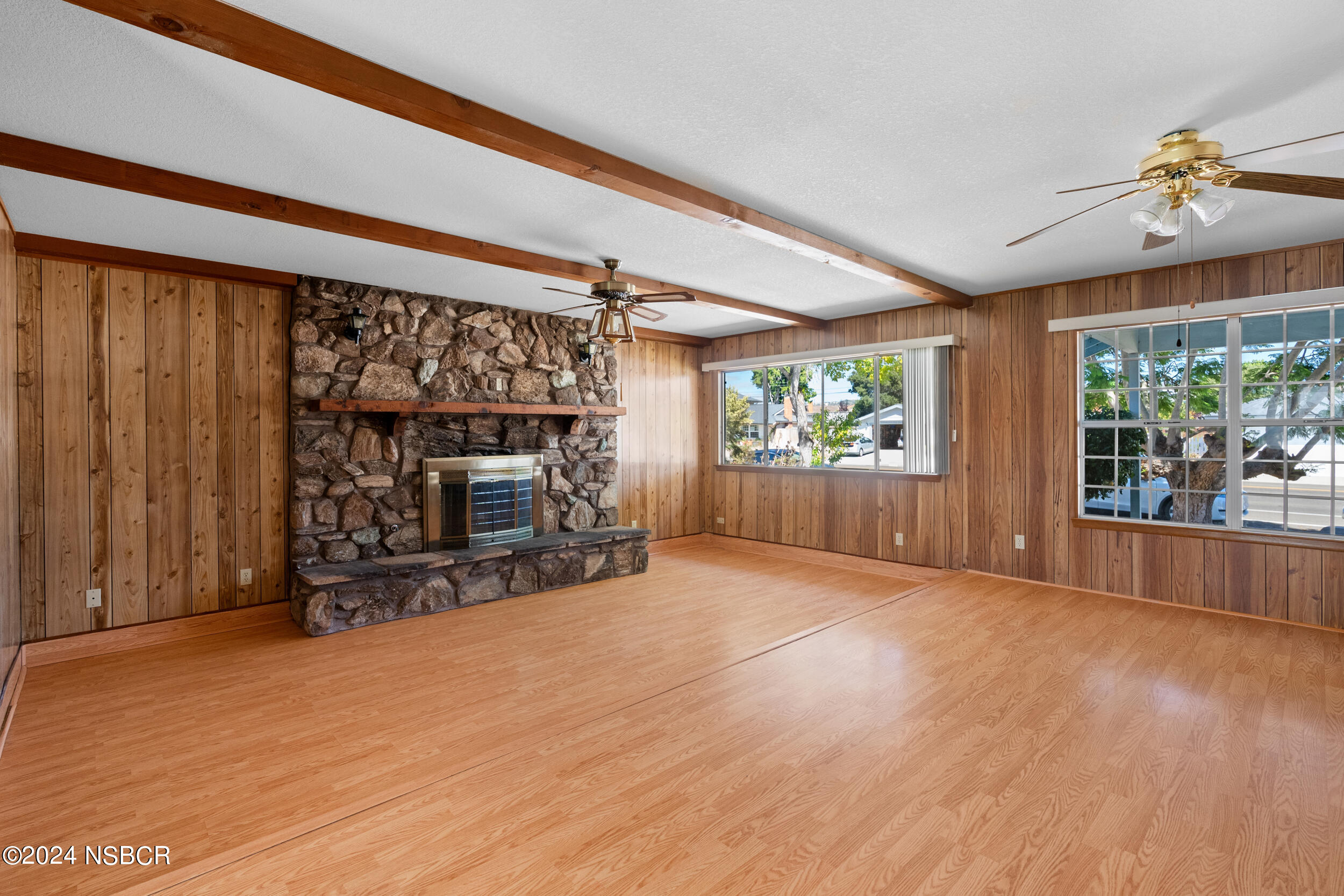 4188 Constellation Road Lompoc, CA 93436 - Photo 5 of 37 a view of an empty room with wooden floor fireplace and a window