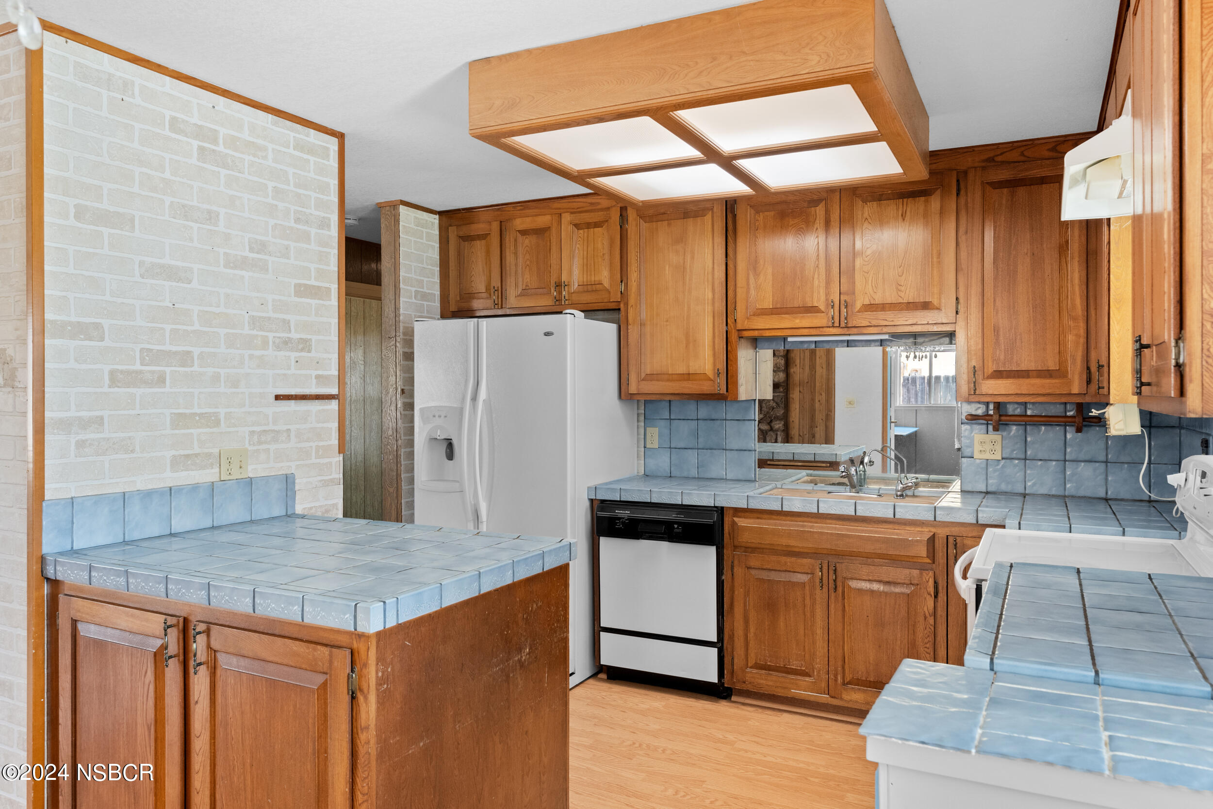 4188 Constellation Road Lompoc, CA 93436 - Photo 10 of 37 a kitchen with stainless steel appliances kitchen island granite countertop a table chairs in it and wooden floors