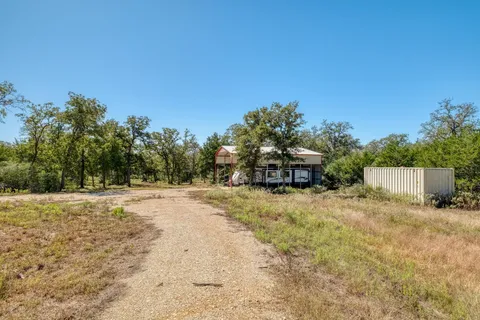 a view of a house with backyard and trees