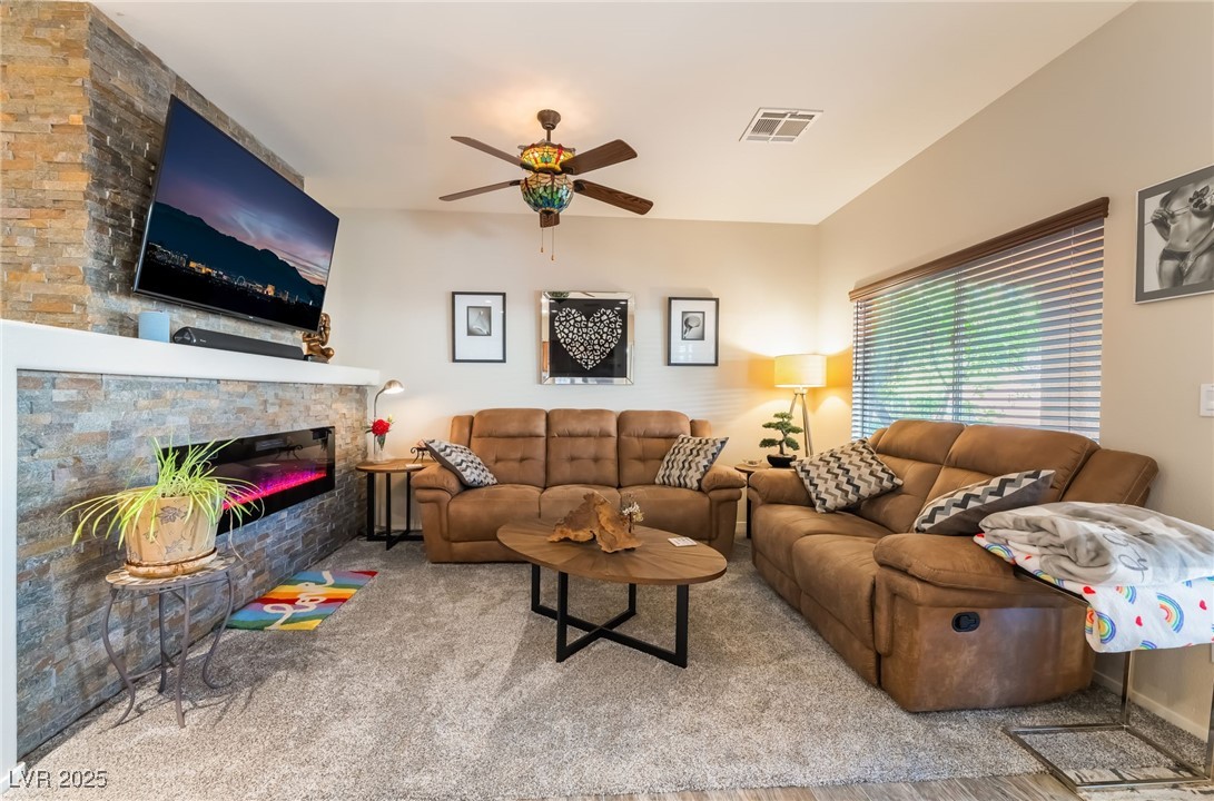 4732 Adriano Way Pahrump, NV 89061 - Photo 13 of 44 Living area with a stone fireplace, ceiling fan, and carpet