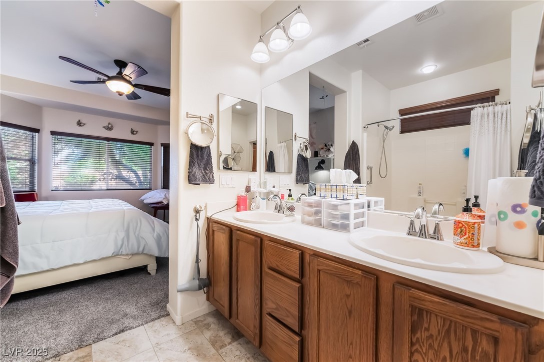 4732 Adriano Way Pahrump, NV 89061 - Photo 30 of 44 Full bathroom with ensuite bathroom, double vanity, ceiling fan, light carpet, and shower / bath combination with curtain