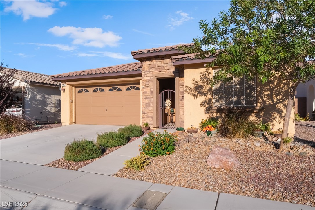 4732 Adriano Way Pahrump, NV 89061 - Photo 4 of 44 Mediterranean / spanish home featuring stone siding, stucco siding, driveway, a tiled roof, and a garage