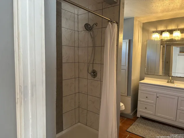 a bathroom with a shower and a sink