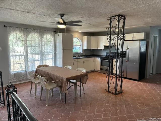 a dining room with stainless steel appliances kitchen island a table chairs in it and wooden floors