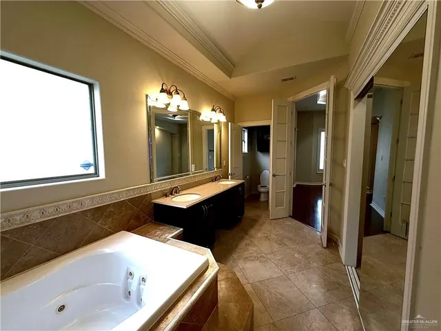 a large bathroom with a tub a double vanity sink and mirror
