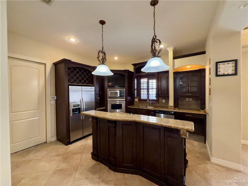 4101 Tyler Avenue McAllen, TX 78503 - Photo 9 of 12 a view of a kitchen with stainless steel appliances granite countertop wooden cabinets and a large window