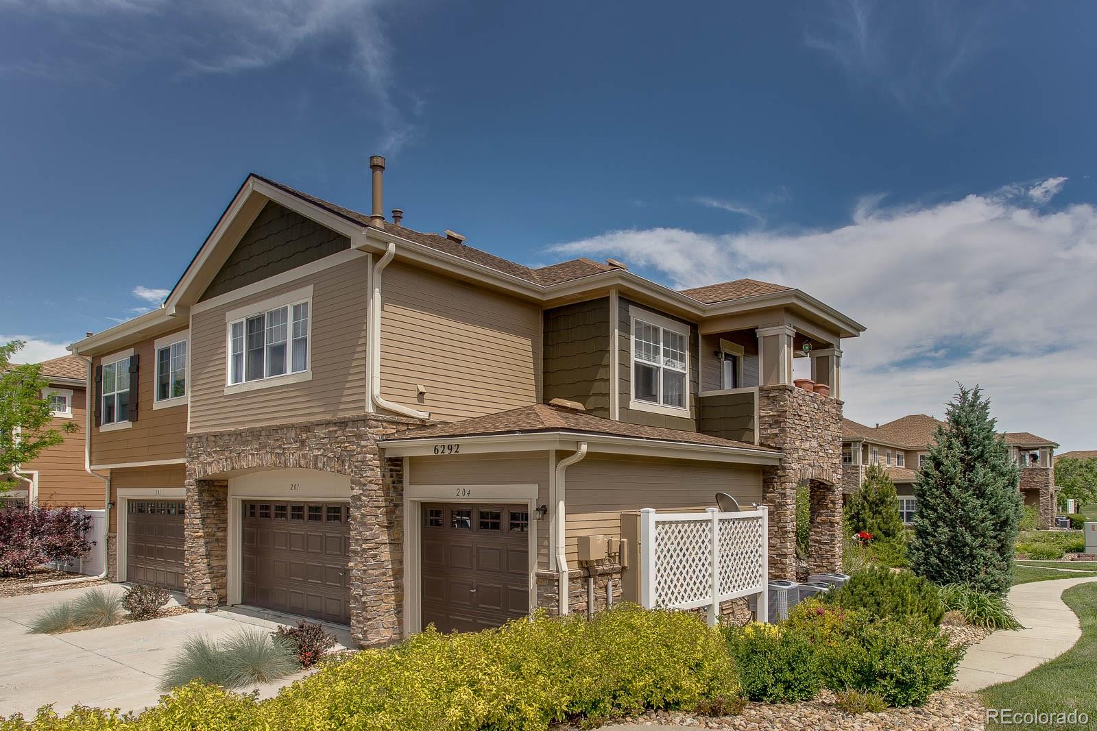 6292 Kilmer Loop, Unit 204 Arvada, CO 80403 - Photo 2 of 25 a front view of a house with a yard