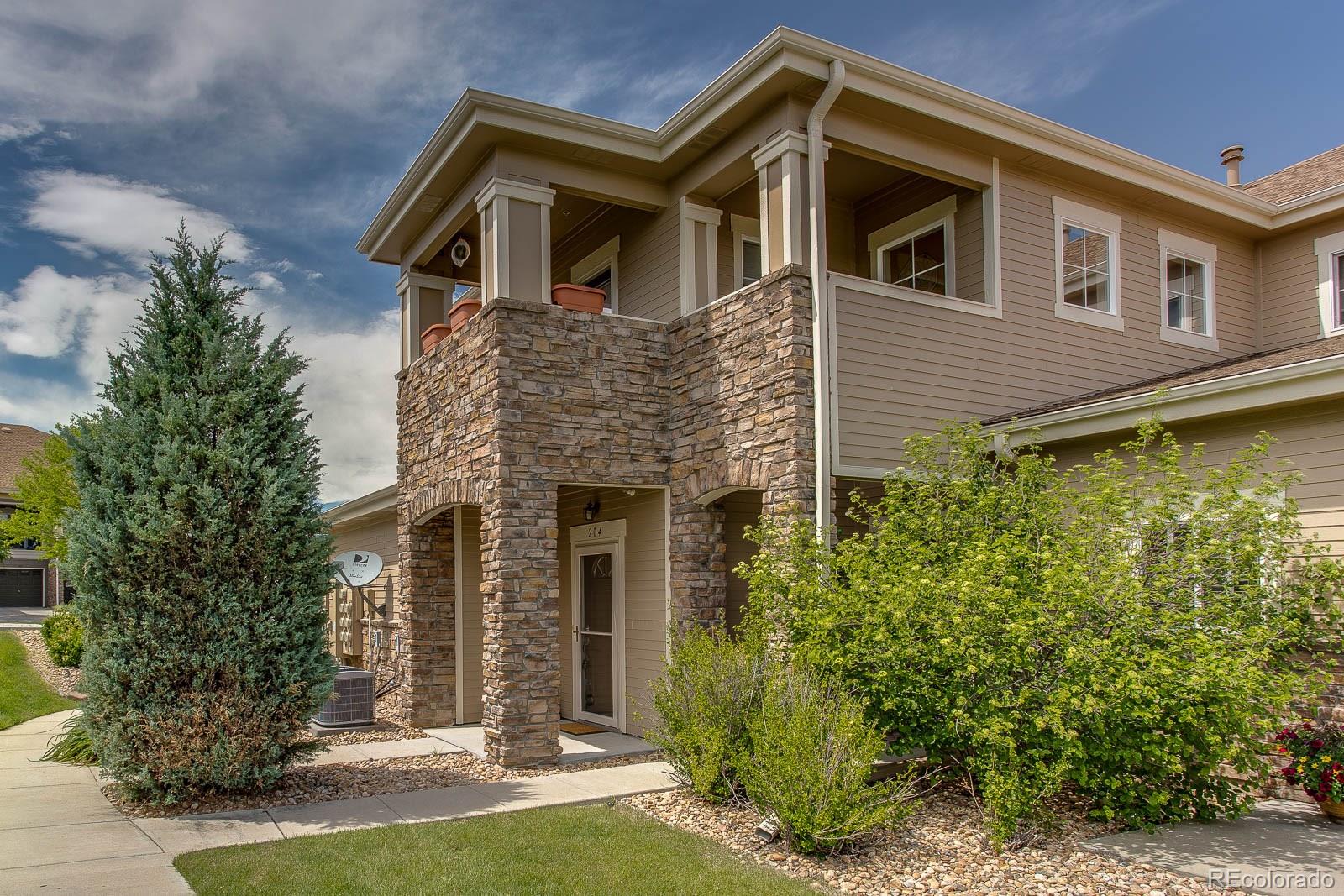 6292 Kilmer Loop, Unit 204 Arvada, CO 80403 - Photo 3 of 25 a front view of a house with a yard