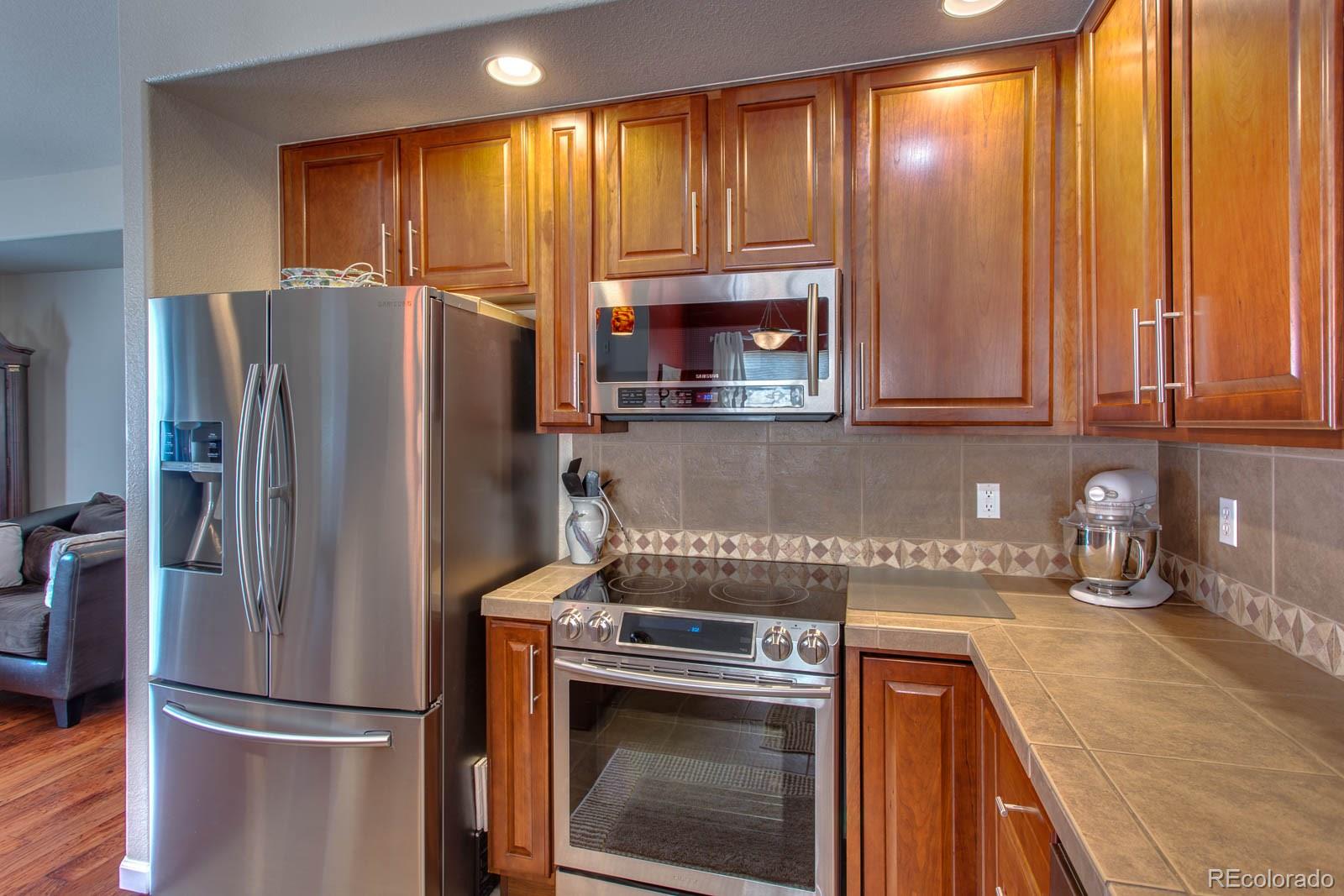 6292 Kilmer Loop, Unit 204 Arvada, CO 80403 - Photo 10 of 25 a kitchen with a refrigerator and a sink